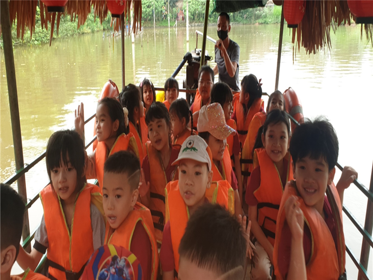 A group of children in life jackets on a boat

Description automatically generated